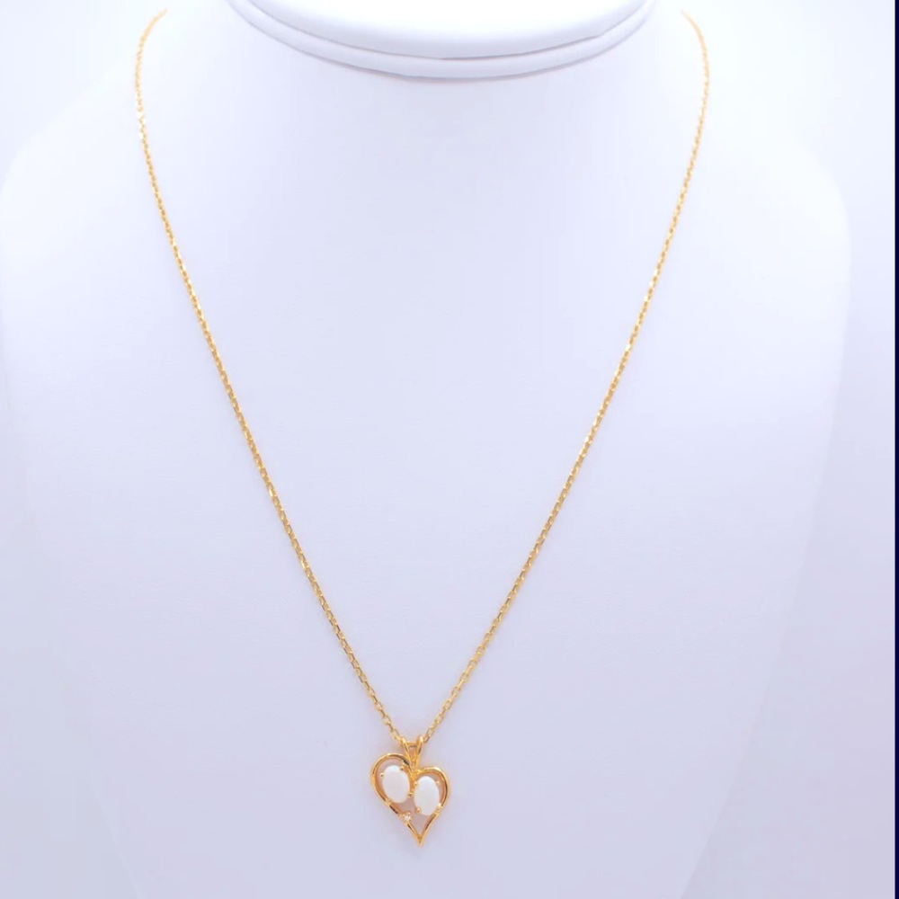 14K Heart pendant with opal stones paired with a necklace.
